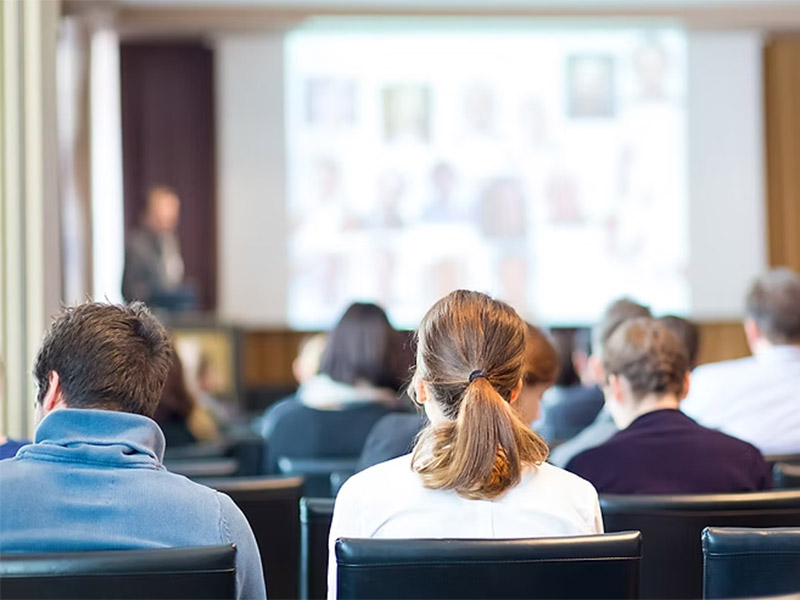 Audience attending a presentation in a conference room.