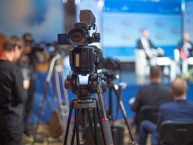 Professional camera filming a conference presentation.