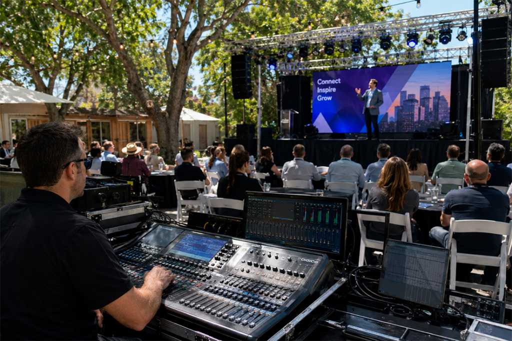A man operating digital display on a corporate event while the event is on
