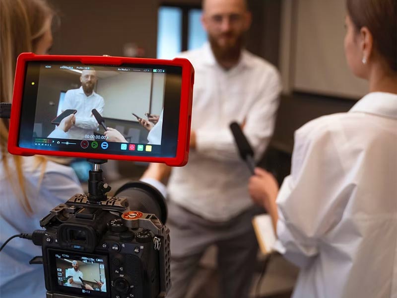 Women interviewing man on camera