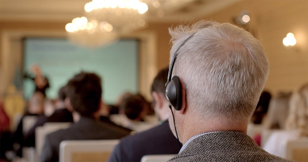 A man listening to the speaker with the headphones