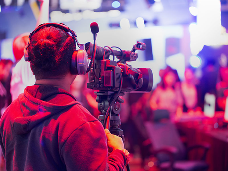 Videographer operating camera at a live event.